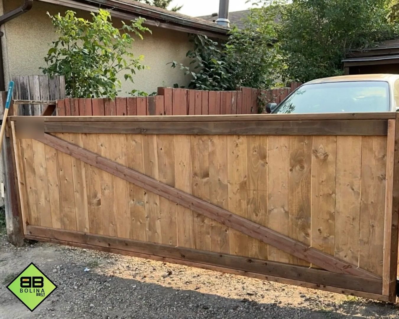 Custom wooden backyard privacy gate with diagonal timber bracing