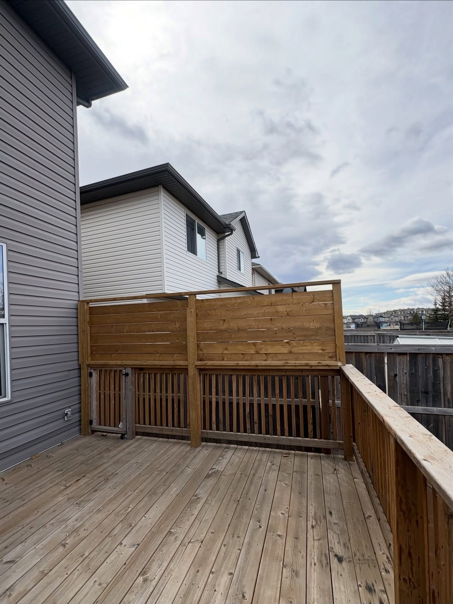 Custom wooden privacy screen on a Calgary backyard deck